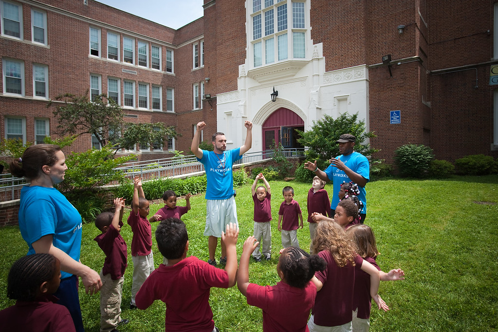 Coaches leading students in game outdoors