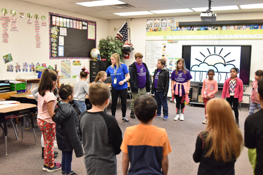 students and coach in classroom